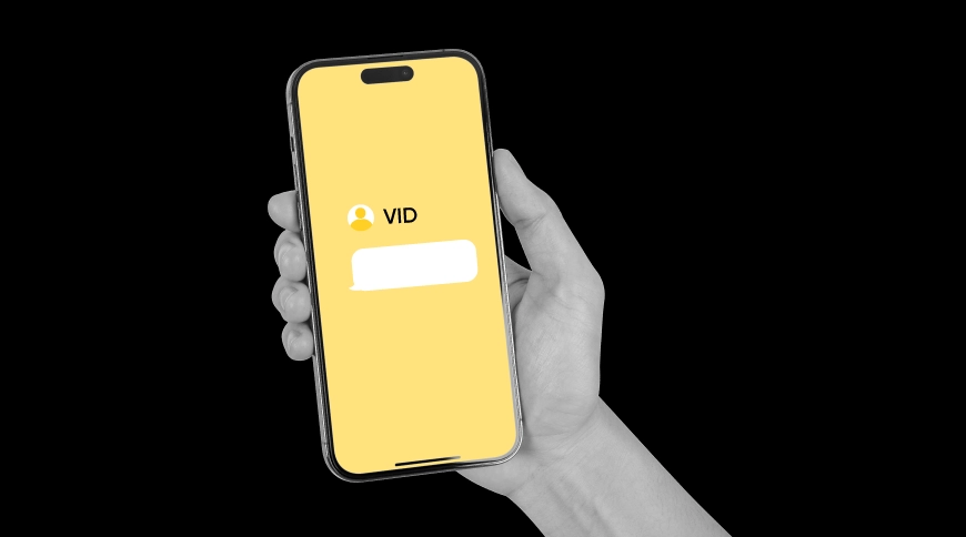 Roka ar telefonu rokā, telefona ekrānā VID logo