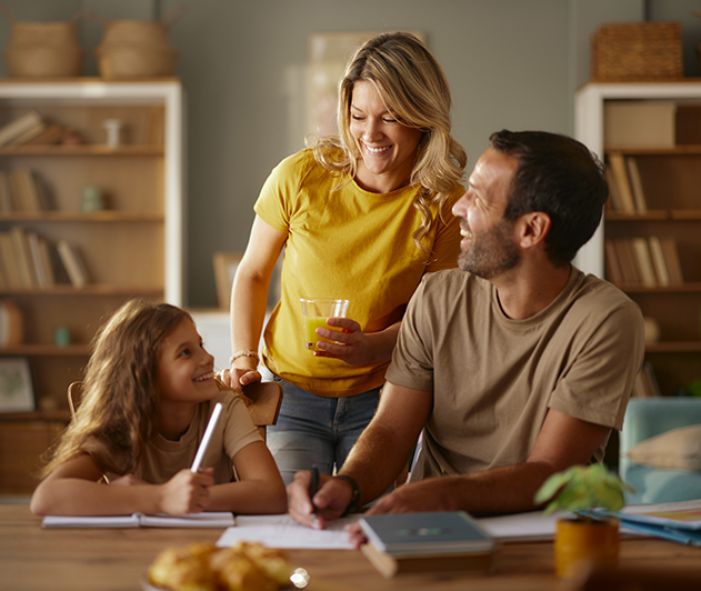 Ģimene pie galda palīdz bērnam ar mājasdarbiem