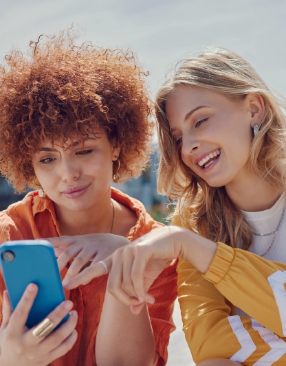 Divas meitenes laimīgas skatās telefonā