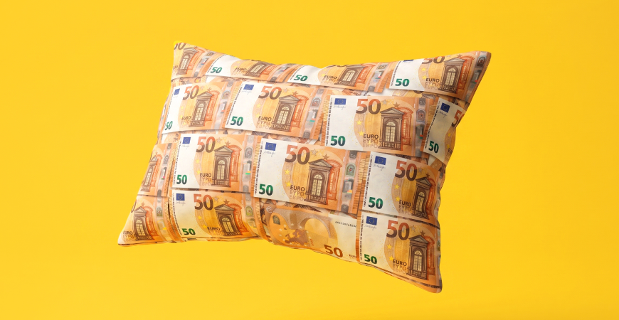 Uz dzeltena fona spilvens ar banknotēm