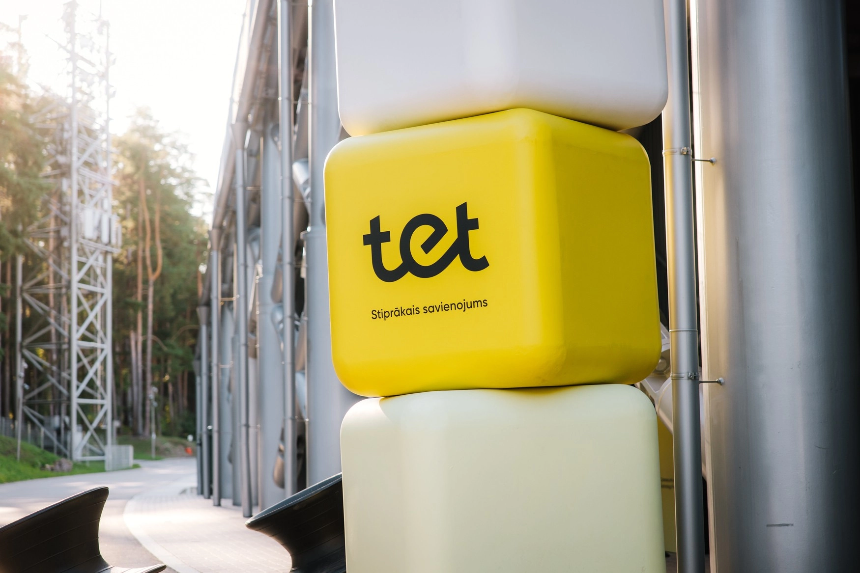Tet logo uz dzeltena kuba pie industriālas ēkas ārpus telpām