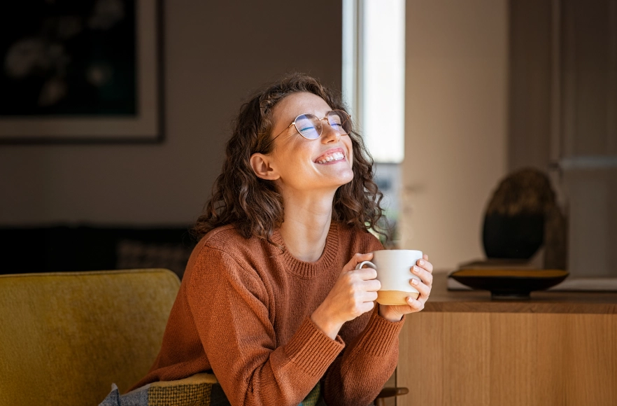 Vīrietis sēž krēslā ar planšetdatoru rokās un bērns pārliecies pāri krēsla malai skatās planšetē