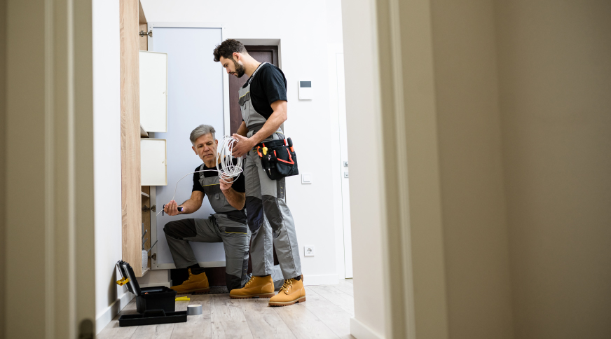 Tehniķi uzstāda interneta iekārtas gaišā telpā