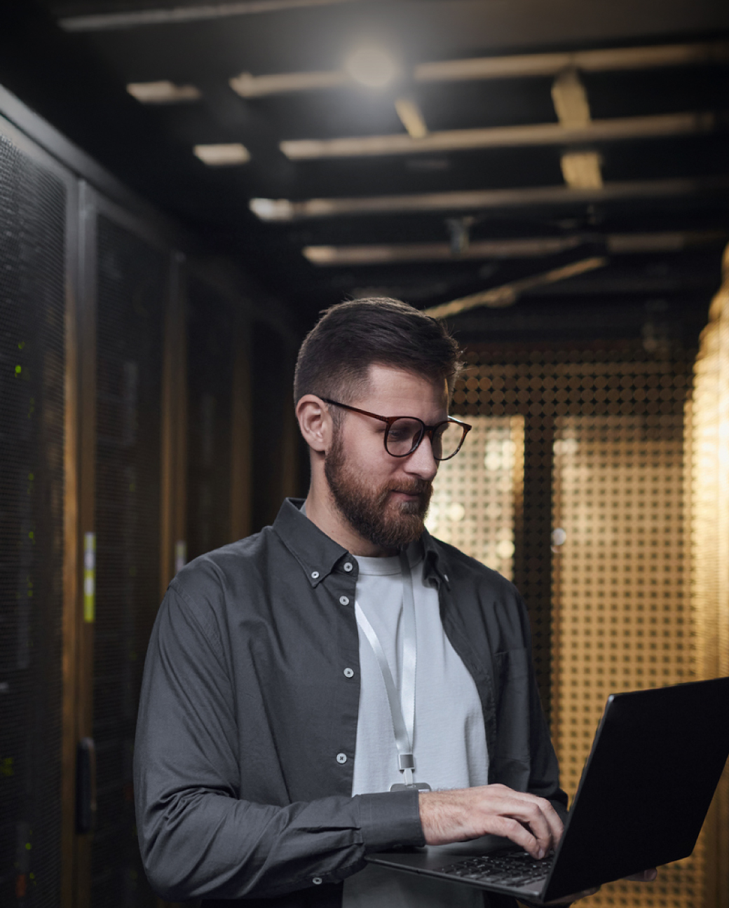 IT speciālists ar klēpjdatoru datu centrā